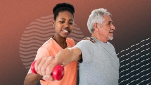 Physical therapist assists an older patient with an upper body exercise